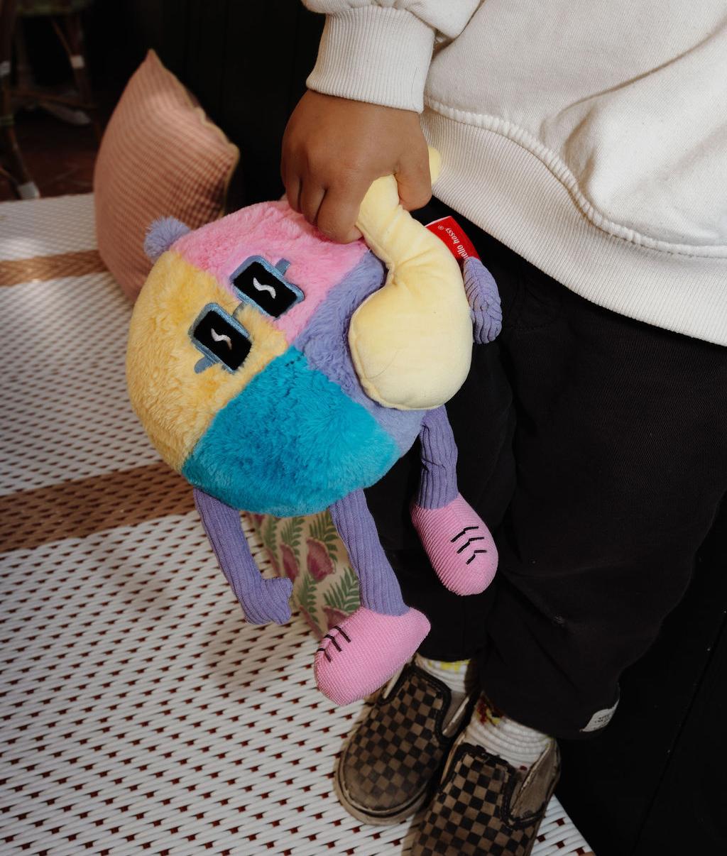 Peluche douce Disco Pop avec note de musique en relief, tenue par un enfant – vue du dessus – Hello Hossy