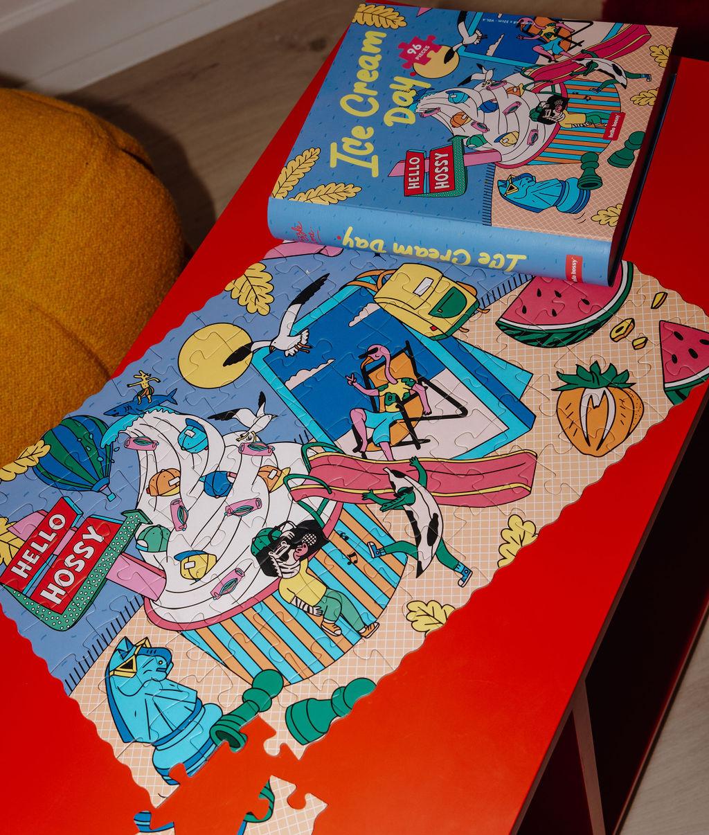 Puzzle coloré "Ice Cream Day" partiellement assemblé sur une table avec la boîte à côté - vue du dessus - Hello Hossy