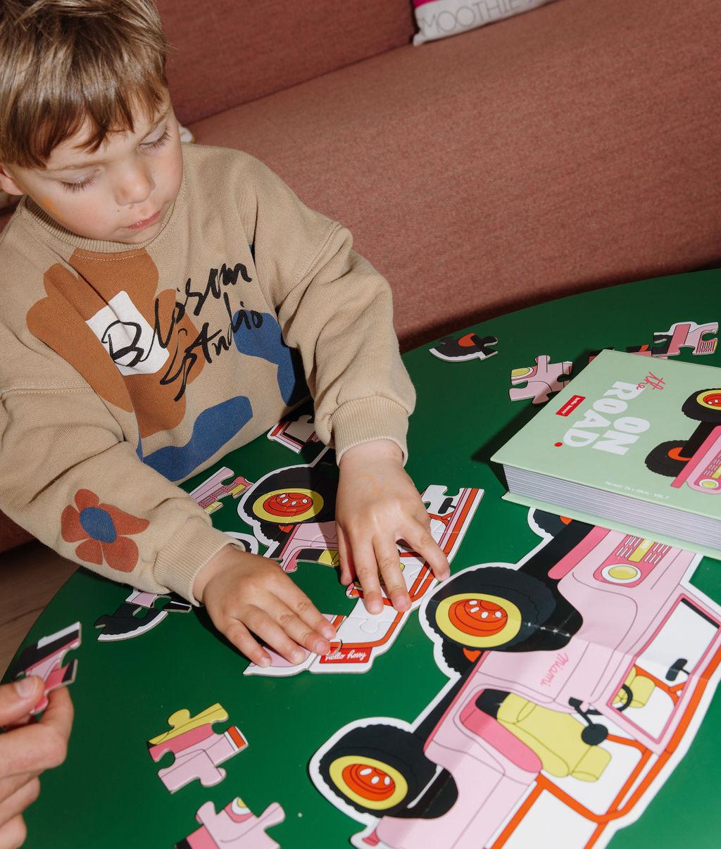 Garçon assemblant le puzzle 24 pièces format voiture sur une table - photo lifestyle - Hello Hossy