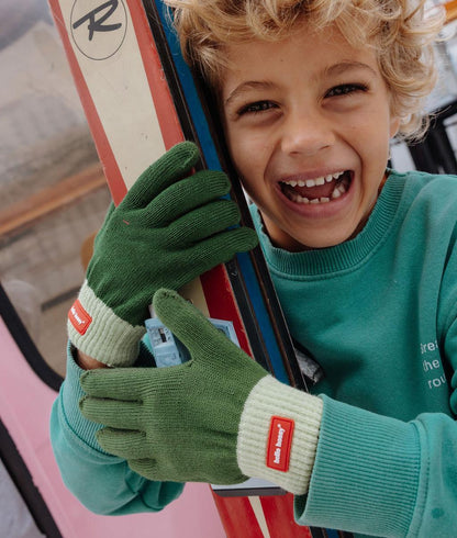Grüne Kinder-Handschuhe mit cremefarbenem Rippenbund und roter Etikette Hello Hossy