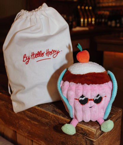 Peluche en forme de gâteau Cherry Cake posée à côté de son pochon réutilisable - photo d'ambiance - Hello Hossy